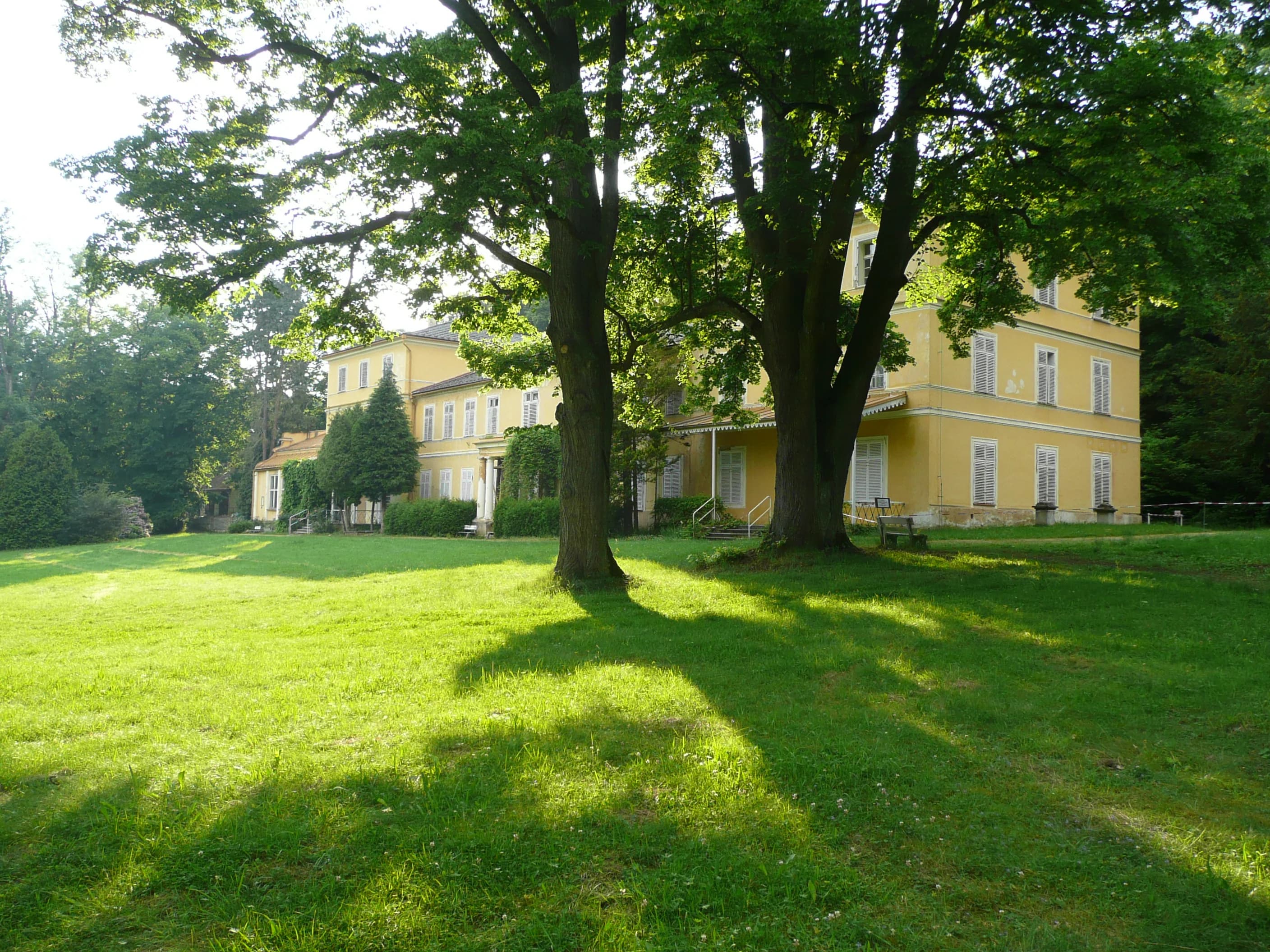 Letní trávník a stromy před zámkem