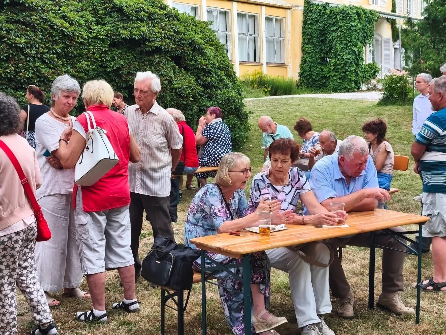 Gäste an den Tischen vor dem Schloss beim Gartenfest.